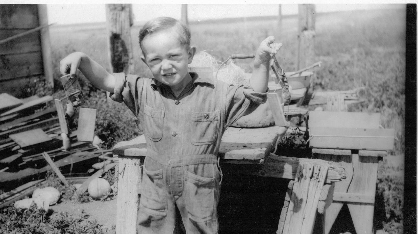 Dan about 3 years old holding multiple mouse traps with mice, very proud of himself