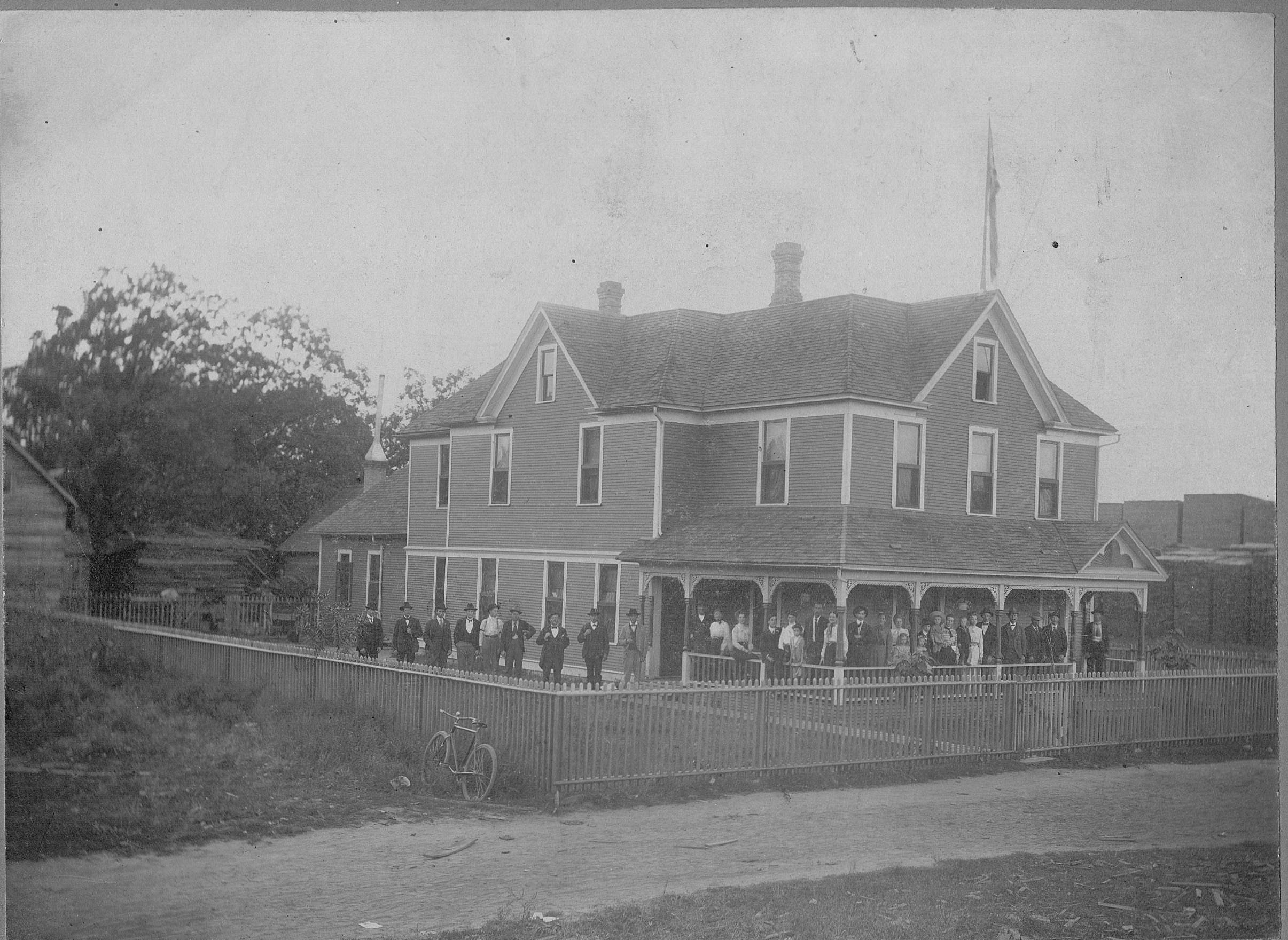 Men & Women standing outside of boarding house